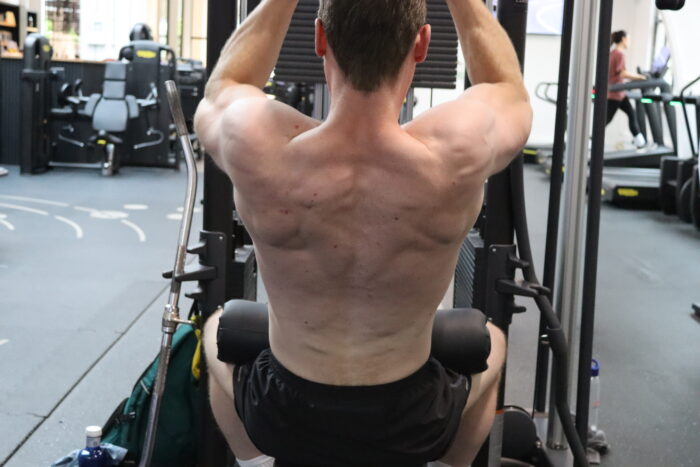 Personal trainer Wijnand Dijkshoorn voert de close grip pulldown uit in sportschool Ceder Gym in Den Haag