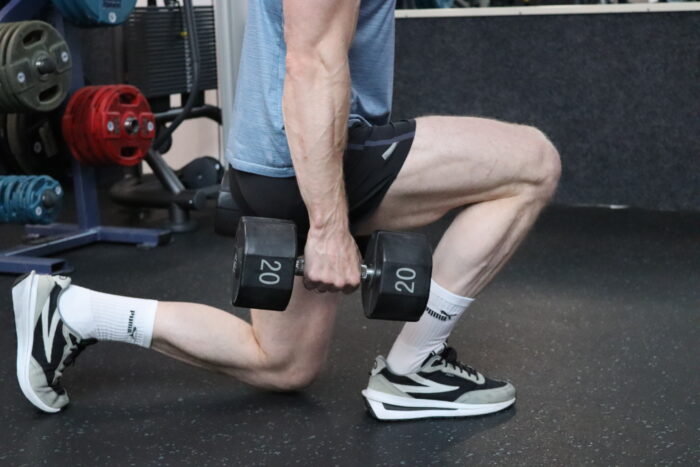 Personal trainer Wijnand Dijkshoorn voert de dumbbell lunge uit in sportschool Ceder Gym in Den Haag